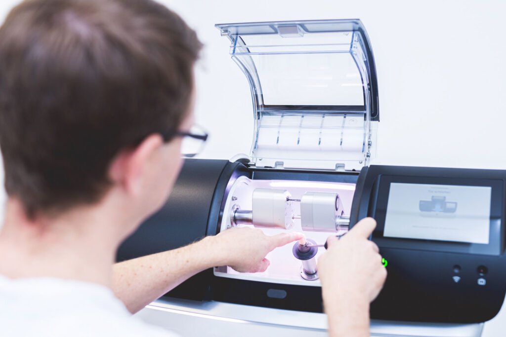 Zahnarzt holt fertigen Zahnersatz aus dem CEREC Gerät